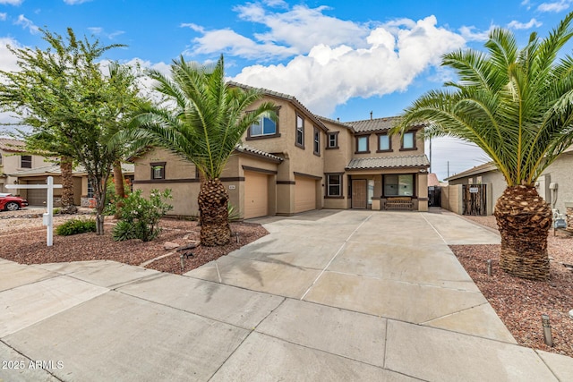 8214 S 48th Dr, Laveen, AZ 85339 - view of front facade featuring a garage, concrete driveway, a tiled roof, and stucco siding