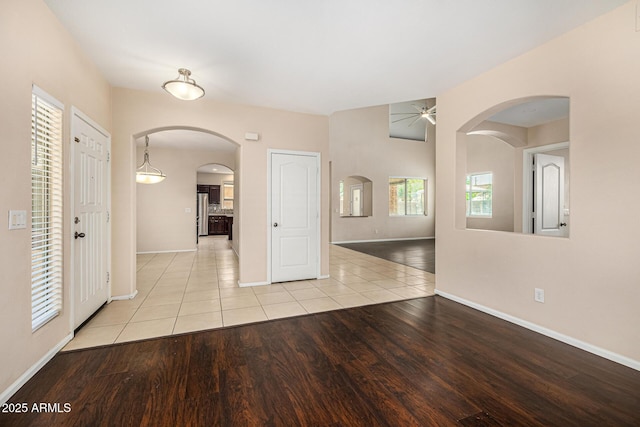 8214 S 48th Dr, Laveen, AZ 85339 - spare room featuring a ceiling fan, arched walkways, wood finished floors, and baseboards