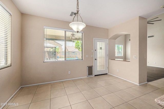 8214 S 48th Dr, Laveen, AZ 85339 - unfurnished dining area featuring light tile patterned floors, baseboards, and arched walkways