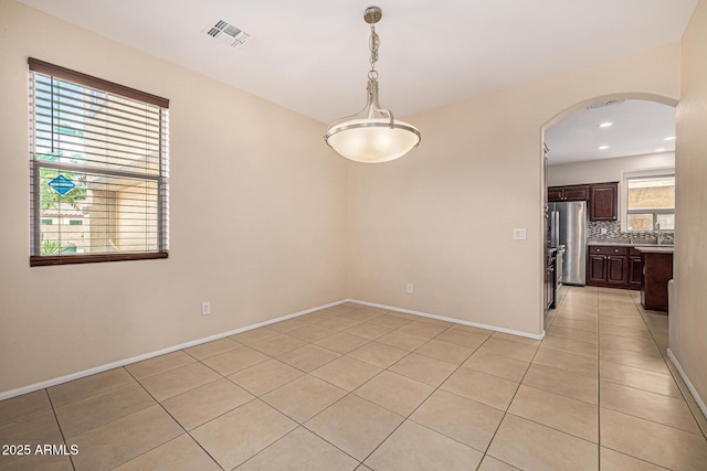 8214 S 48th Dr, Laveen, AZ 85339 - unfurnished room with light tile patterned floors, arched walkways, baseboards, and recessed lighting