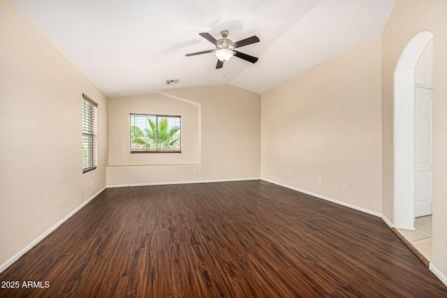 8214 S 48th Dr, Laveen, AZ 85339 - spare room with dark wood-style flooring, lofted ceiling, ceiling fan, baseboards, and arched walkways