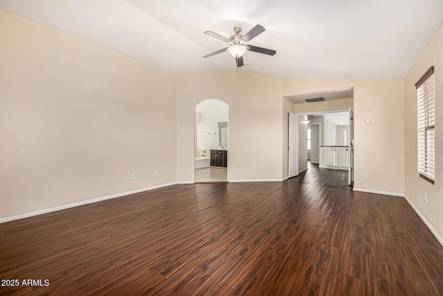 8214 S 48th Dr, Laveen, AZ 85339 - unfurnished living room with arched walkways, ceiling fan, dark wood-style flooring, and baseboards