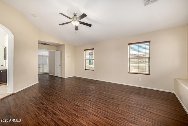 8214 S 48th Dr, Laveen, AZ 85339 - spare room with dark wood-style floors, ceiling fan, healthy amount of natural light, arched walkways, and vaulted ceiling