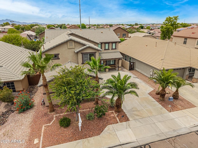8214 S 48th Dr, Laveen, AZ 85339 - view of front of home featuring stucco siding, a tiled roof, a residential view, concrete driveway, and covered porch