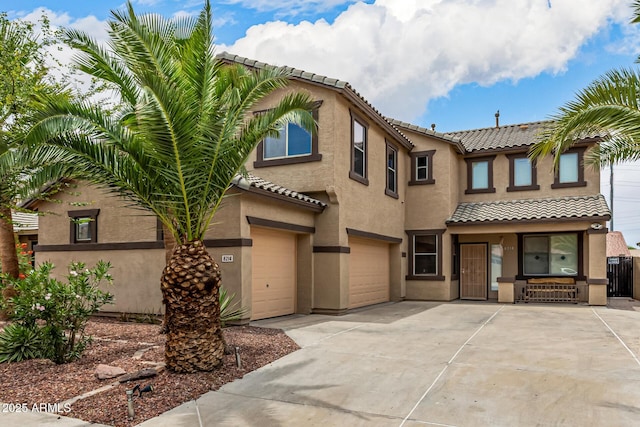 8214 S 48th Dr, Laveen, AZ 85339 - view of property with a tile roof, an attached garage, concrete driveway, stucco siding, and covered porch
