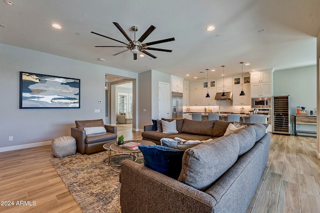 living room with light hardwood / wood-style floors and ceiling fan