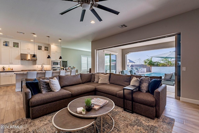 living room featuring ceiling fan and light hardwood / wood-style floors