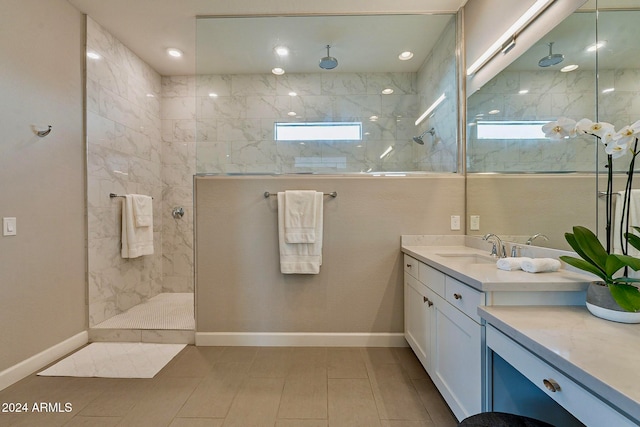 bathroom with tiled shower, tile patterned floors, and vanity