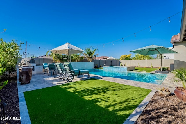 view of pool with a lawn and a patio area