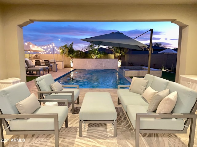 pool at dusk featuring an outdoor hangout area, an in ground hot tub, pool water feature, and a patio area