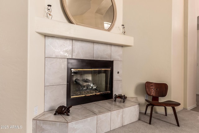 interior details featuring a tile fireplace, carpet flooring, and baseboards