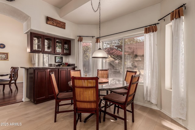 dining space with light wood-style flooring and baseboards