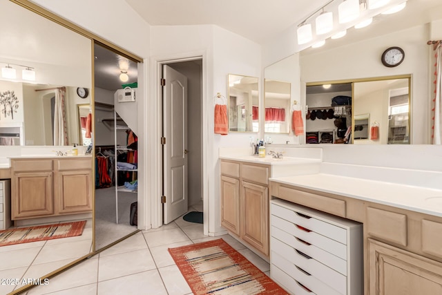 bathroom featuring tile patterned flooring, a spacious closet, and vanity