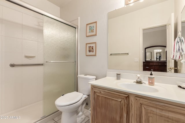 bathroom with toilet, a shower stall, and vanity