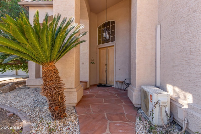 entrance to property with ac unit and stucco siding