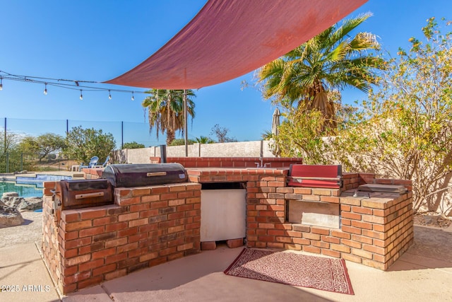 view of patio featuring area for grilling, a grill, and a fenced in pool