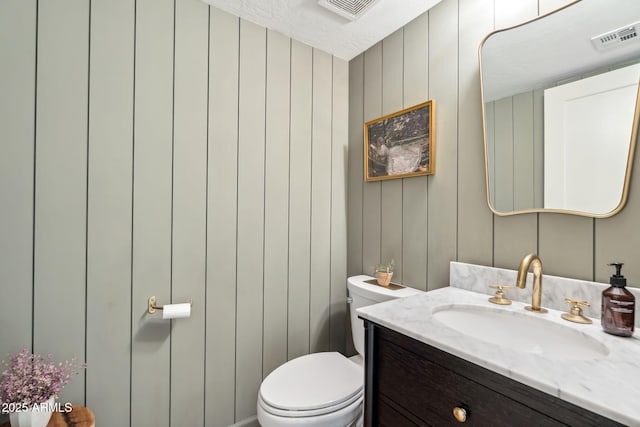 half bath featuring toilet and vanity