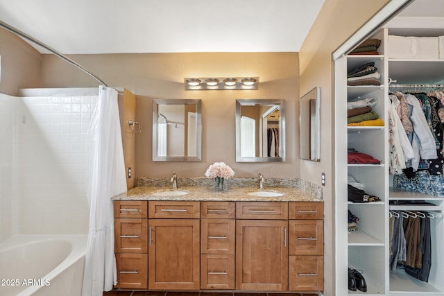 full bath with double vanity, a spacious closet, and shower / bath combination with curtain