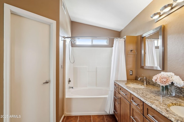 bathroom with lofted ceiling, double vanity, shower / tub combo, and tile patterned floors