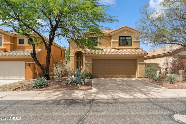mediterranean / spanish-style home with stucco siding, a tile roof, concrete driveway, and a garage