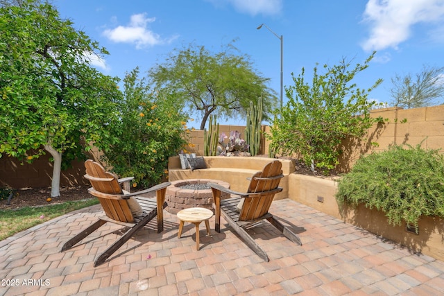 view of patio featuring an outdoor fire pit and a fenced backyard