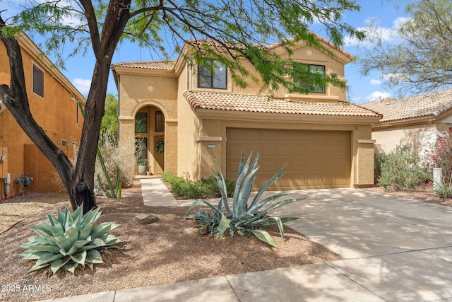 mediterranean / spanish house featuring stucco siding, a tile roof, an attached garage, and concrete driveway