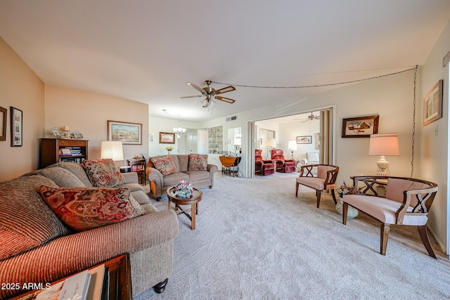 carpeted living room featuring ceiling fan with notable chandelier