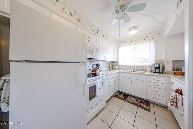 kitchen with white appliances, white cabinets, ceiling fan, light tile patterned floors, and sink