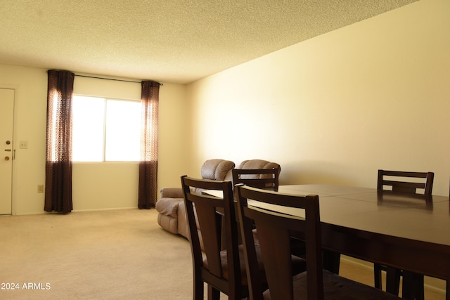 carpeted dining area with a textured ceiling