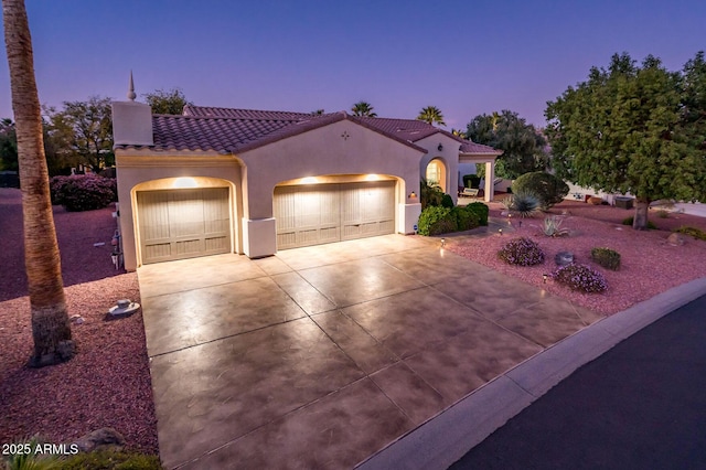 mediterranean / spanish home featuring a garage