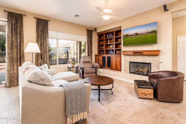 living room with ceiling fan, a fireplace, and built in features