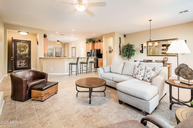 living room featuring ceiling fan with notable chandelier