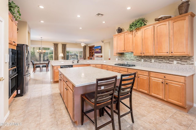 kitchen with a center island, hanging light fixtures, kitchen peninsula, a breakfast bar area, and black appliances