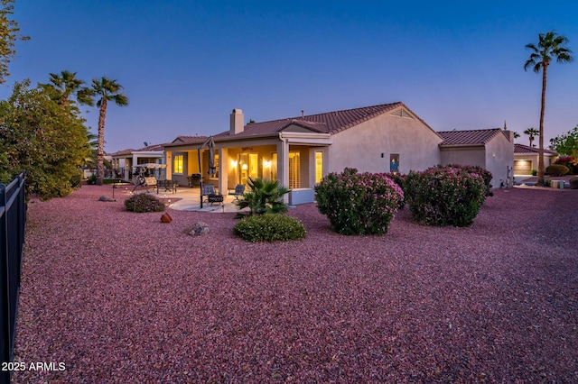 back house at dusk with a patio