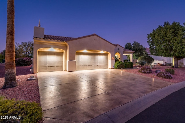 mediterranean / spanish home featuring a garage