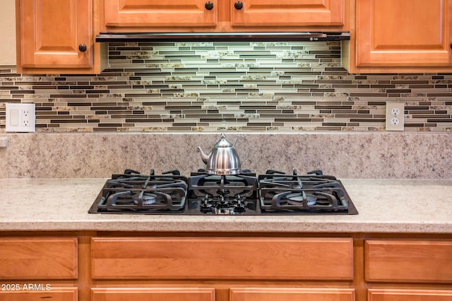 room details featuring tasteful backsplash and black gas stovetop