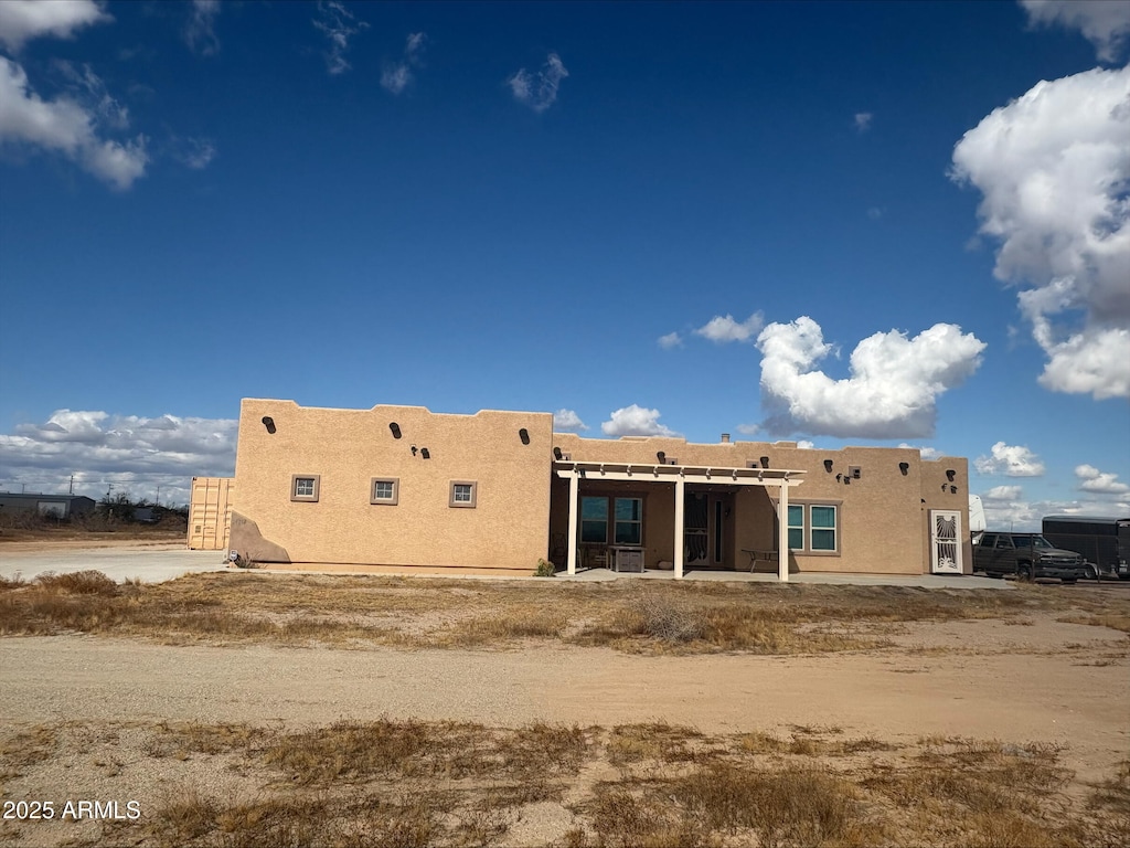 rear view of property featuring stucco siding