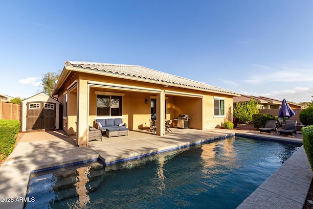 back of property featuring stucco siding, an outdoor structure, a storage shed, outdoor lounge area, and a patio
