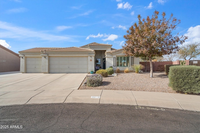 view of front of home with concrete driveway, an attached garage, fence, and stucco siding