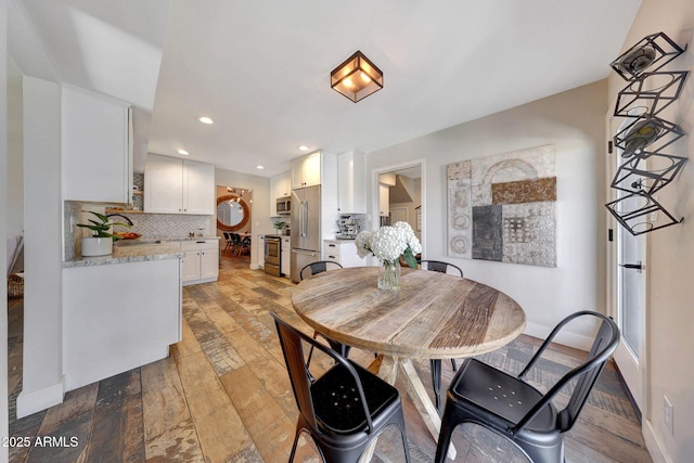 dining space with light wood finished floors, baseboards, and recessed lighting