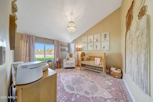 bedroom with vaulted ceiling, a crib, and a chandelier