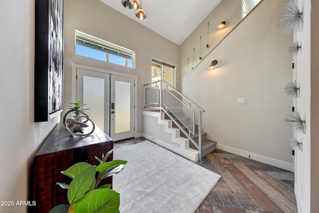 foyer entrance featuring baseboards, stairway, and french doors