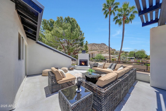 view of patio featuring an outdoor living space with a fireplace and a mountain view