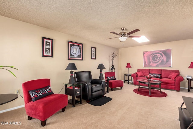 living area with ceiling fan, carpet, baseboards, and a textured ceiling