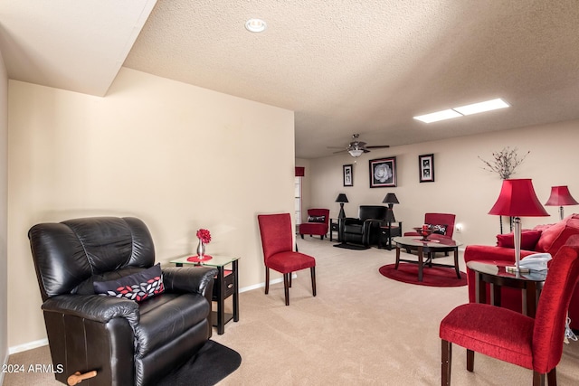 living area with carpet flooring, a textured ceiling, baseboards, and ceiling fan