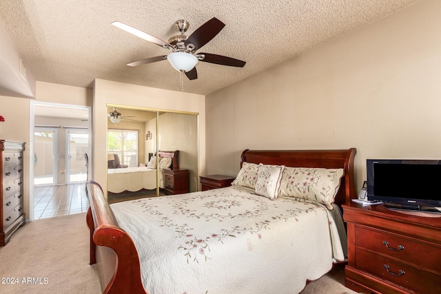 carpeted bedroom with a closet, a textured ceiling, and a ceiling fan