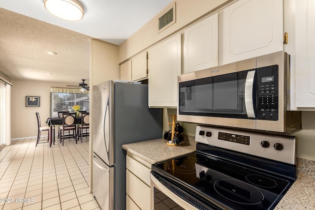 kitchen featuring a textured ceiling, light countertops, white cabinets, visible vents, and stainless steel appliances