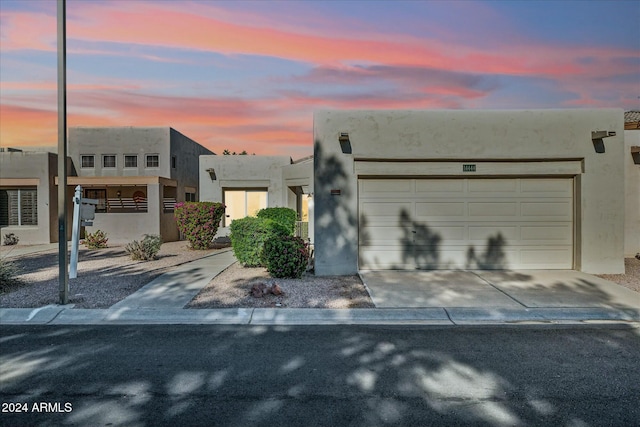 pueblo-style home featuring a garage