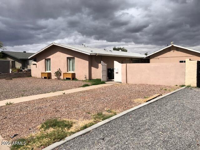 view of front of house with stucco siding and fence