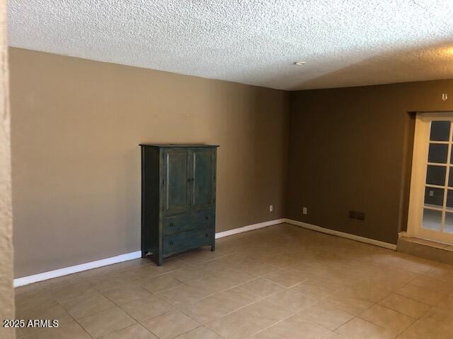 unfurnished room featuring baseboards and a textured ceiling